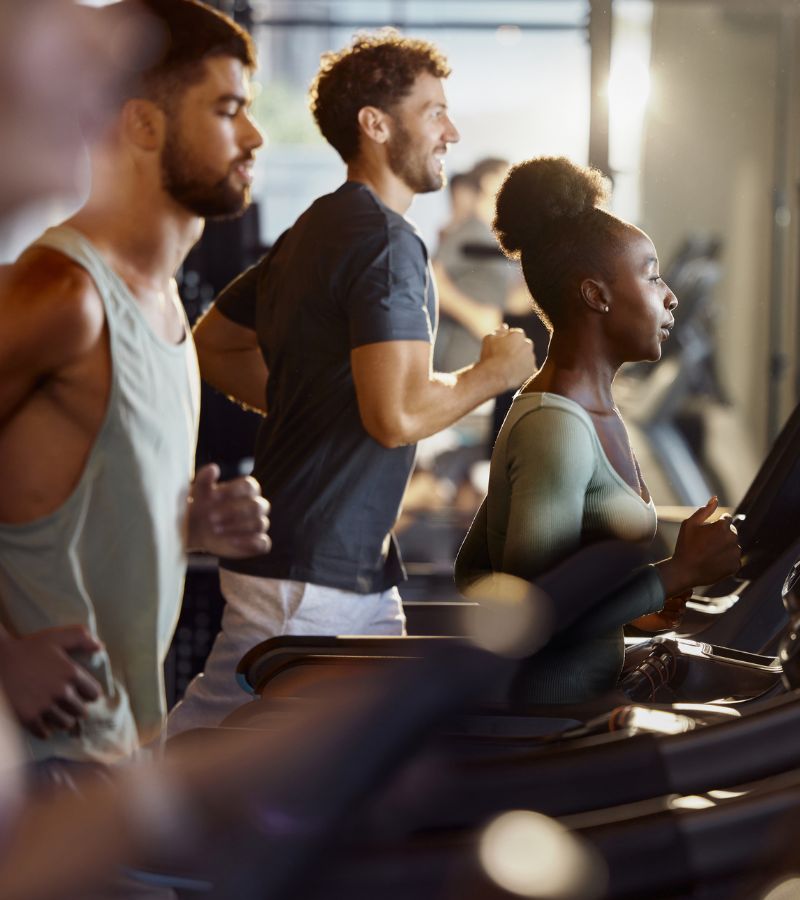 Members using treadmills in the cardio training area at Gold’s Gym East End in Richmond VA, featuring modern fitness equipment and natural lighting.