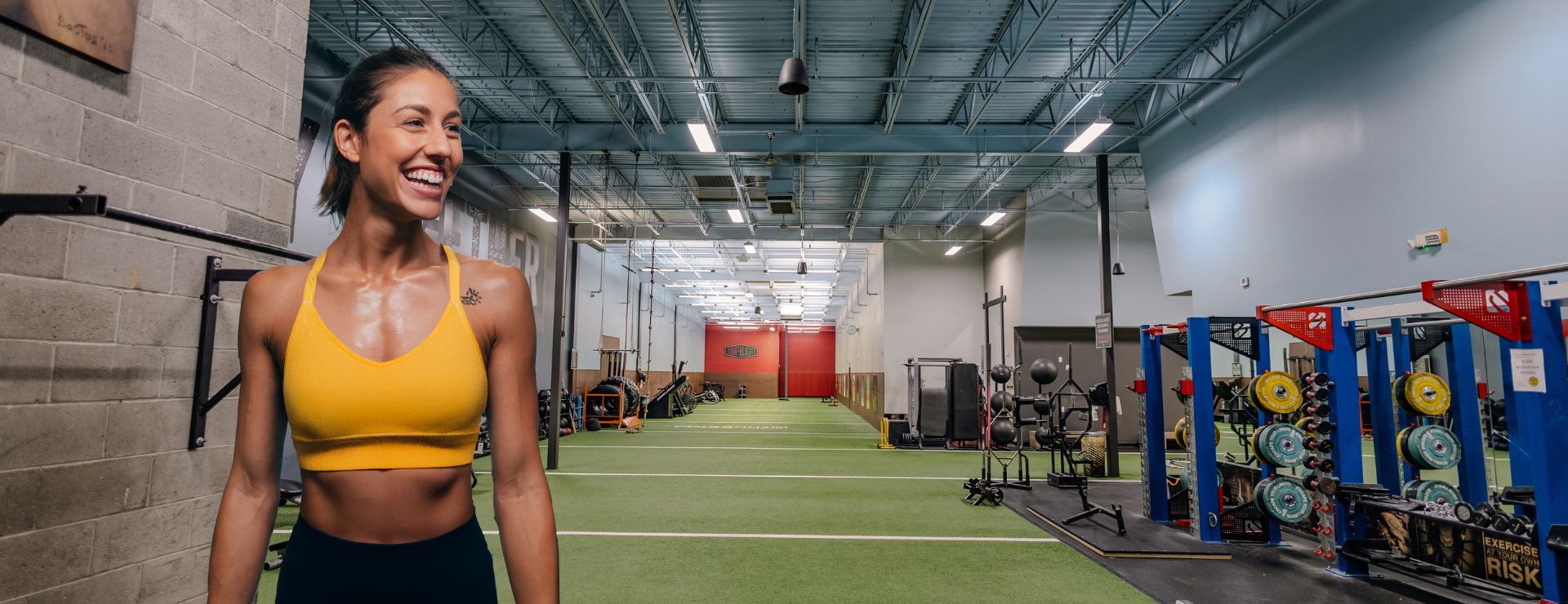 Smiling member after a workout in the training area at Gold’s Gym East End in Richmond VA, promoting free gym pass.